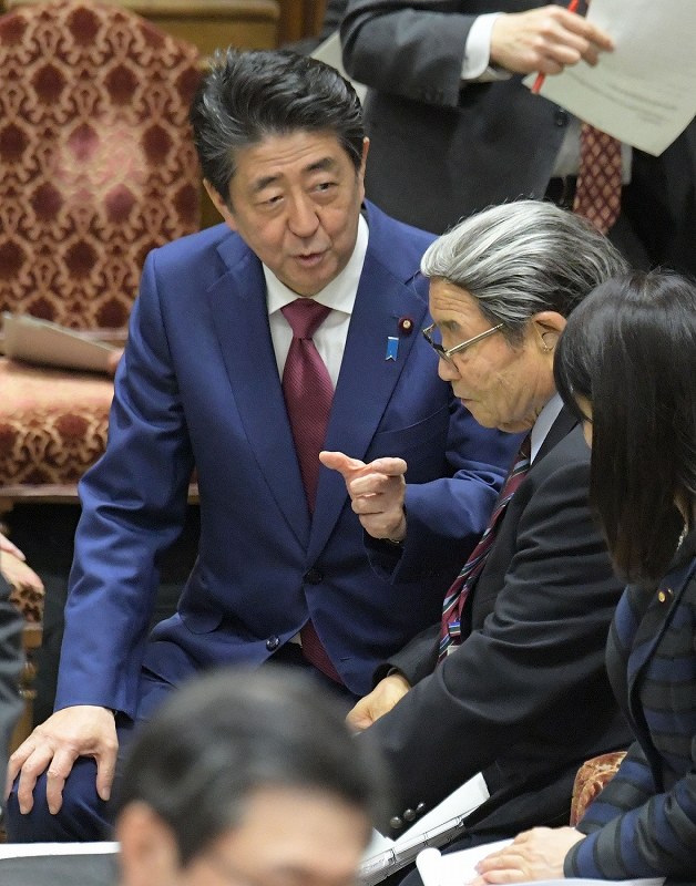 午後の衆院予算委員会集中審議が始まる前に北村誠吾地方創生担当相（奥から２人目）と協議する安倍晋三首相（奥）＝国会内で２０２０年２月１２日午後０時５８分、川田雅浩撮影