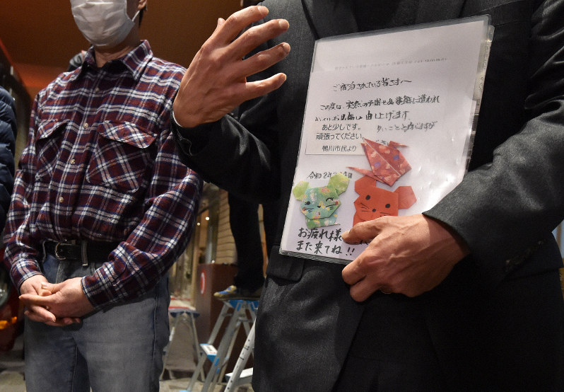 地元住民から寄せられた応援メッセージを手に取材に応じる帰宅が決まった政府チャーター機第1便の帰国者=千葉県勝浦市で2020年2月12日午後6時51分、滝川大貴撮影