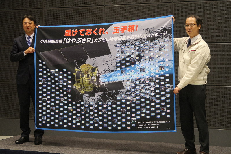 大正製薬の宇宙応援プロジェクト発表会で、応援メッセージを津田雄一・はやぶさ2プロジェクトマネジャー(右)へ贈呈する梅岡久・同社マーケティング本部長=東京都江東区の日本科学未来館で2020年2月14日、永山悦子撮影