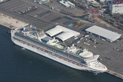 横浜港に停泊中のクルーズ船「ダイヤモンド・プリンセス」。中央右に救急車両が待機する＝横浜市鶴見区の大黒ふ頭で２０２０年２月１２日、本社ヘリから尾籠章裕撮影