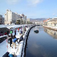 観光客でにぎわう小樽運河。小作争議があった当時の運河は左側に2倍の幅があり、倉庫が建ち並んでいた=北海道小樽市で