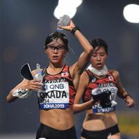 女子２０キロ競歩で、給水しながらコースを周回する岡田（手前）＝カタール・ドーハで２０１９年９月、久保玲撮影