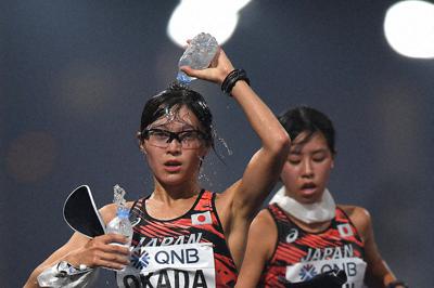 女子２０キロ競歩で、給水しながらコースを周回する岡田（手前）＝カタール・ドーハで２０１９年９月、久保玲撮影