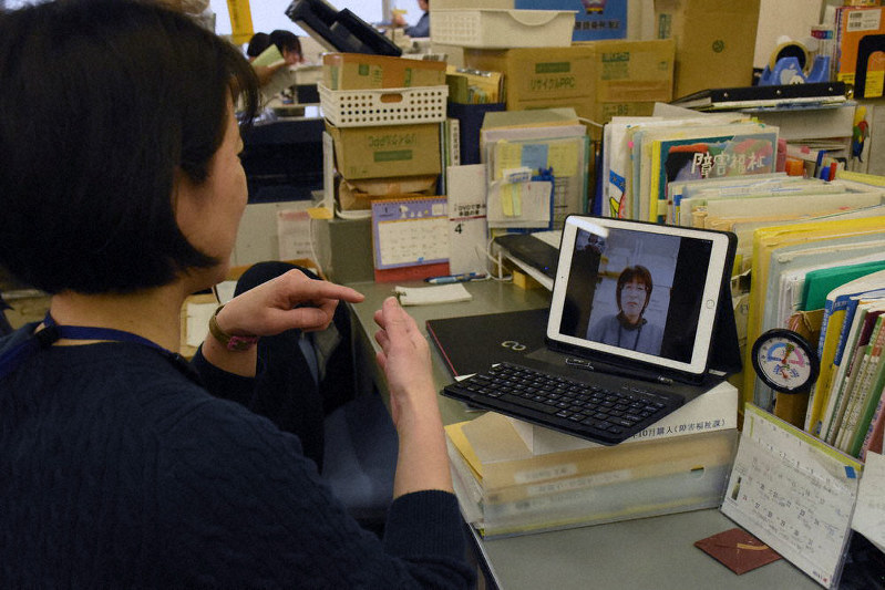 ラインのテレビ電話機能を活用し、手話で応対する市職員=大津市役所で、小西雄介撮影