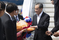 China's Foreign Minister Wang Yi, right, arrives at Wattay International Airport in Vientiane, Laos, on Feb. 19, 2020. (AP Photo/Sakchai Lalit)