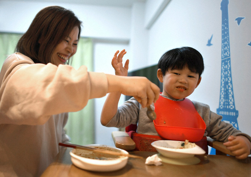母直美さんと食事中、笑顔を見せる河越奏さん=大阪府吹田市で2020年2月4日、久保玲撮影