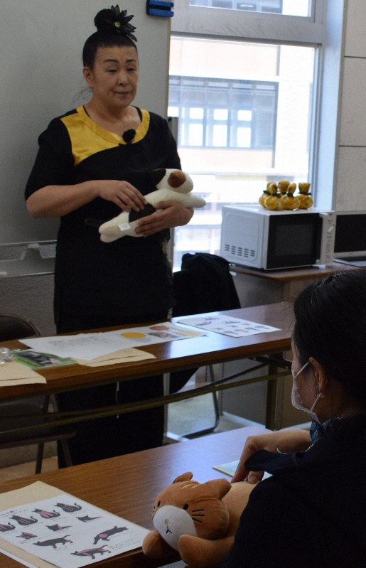 猫マッサージを教える松添さん(左)=北九州市八幡東区のさわらびガーデンモール八幡で2020年2月22日午前10時59分、津島史人撮影