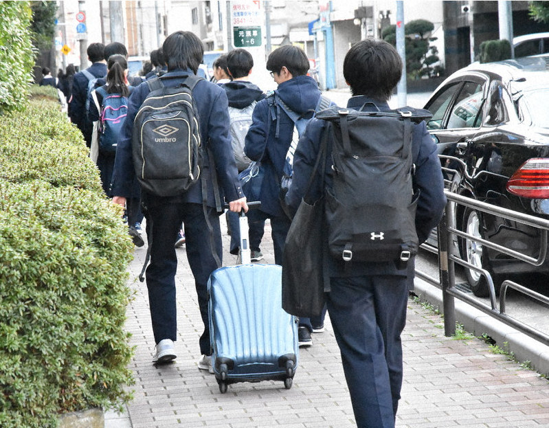 今年度最後の授業を終え下校する白鷗高校の生徒たち。たくさんの道具や課題を持ち帰るため、キャリーバッグを引く姿も見られた=東京都台東区で2020年2月28日午後2時49分、大久保昂撮影