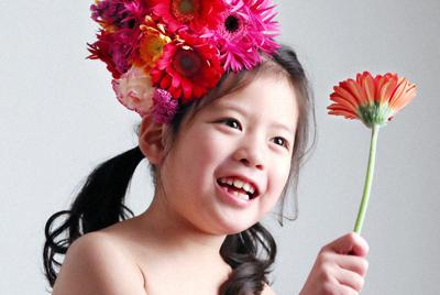 選んだ赤いガーベラを手にカメラマンに笑顔を見せる石井杏奈ちゃん＝大阪府八尾市で、梅田麻衣子撮影