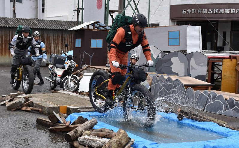 導入した「ファットバイク」で水たまりを進む隊員=徳島県石井町で