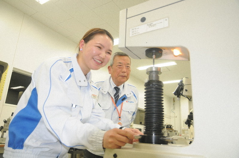 藤田螺子工業で技能実習生として働き、愛知県の聖火ランナーに選ばれたルハグワドルジ・ナンデンエルデネさん。右は同社の田川勝彦顧問=愛知県岡崎市で