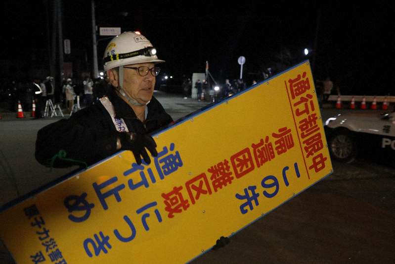 避難指示が解除され、ゲート(奥)を開け、看板を撤去する作業員=福島県双葉町で2020年3月4日午前0時1分、和田大典撮影