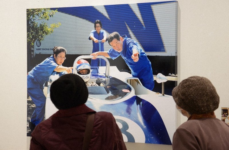 レーシングチームにふんした作品を見入る来館者たち=福井県あわら市の金津創作の森美術館で、大森治幸撮影