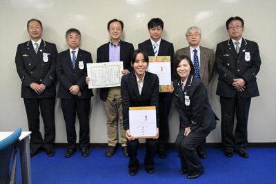 JR東日本から感謝状を受けた学生と指導した阿野幸一教授(後列右から4番目)、国際学部長の奥田孝晴教授(後列右から2番目)とJR東日本社員＝文教大提供