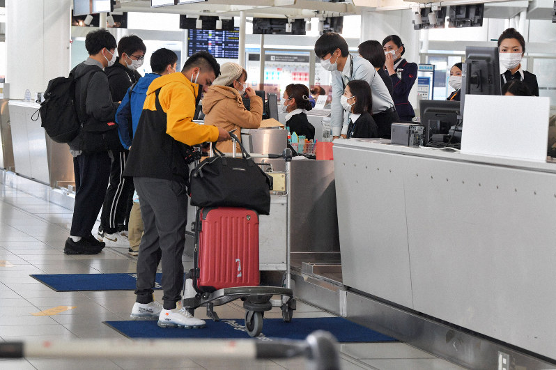 韓国行きの航空会社のカウンターで搭乗手続きをする乗客たち=福岡市博多区の福岡空港で2020年3月6日午前8時57分、森園道子撮影