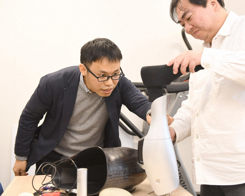 最新技術を投入した義足を前に開発メンバーと言葉を交わすBionicM社長の孫小軍さん(左)=東京都文京区の同社オフィスで2020年1月31日、藤井太郎撮影
