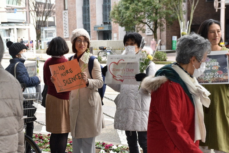 花や手作りのプラカードを手に、性暴力の根絶を訴える参加者ら=金沢市武蔵町で2020年3月8日、日向梓撮影