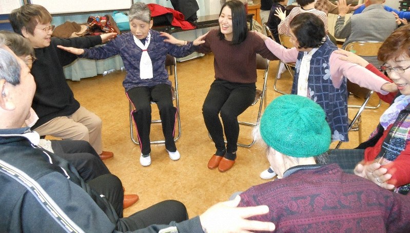 学生の指導の下、認知症の予防効果があるとされる運動「コグニサイズ」に取り組む参加者ら=大阪市東淀川区で、岡崎大輔撮影