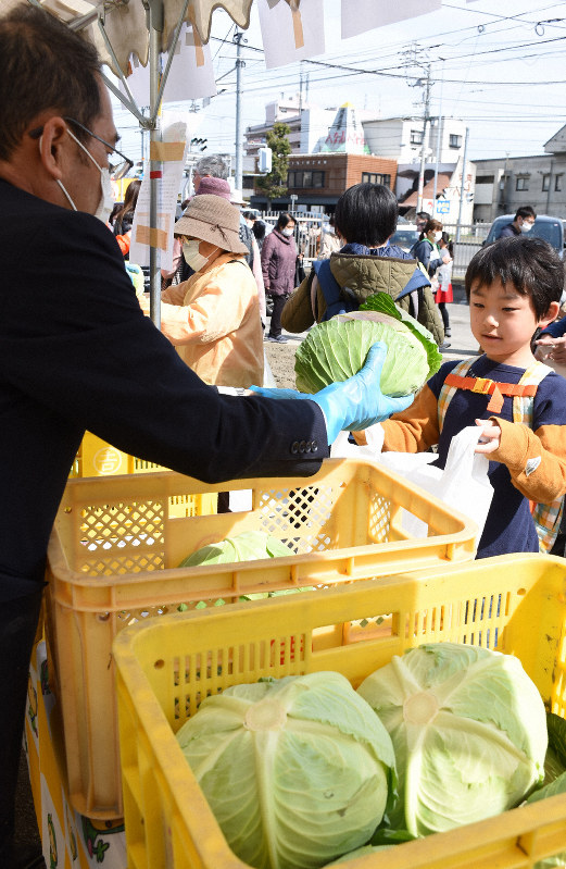 臨時休校のため余った給食用のキャベツを無料で受け取る子どもら=松山市北土居5のJA松山市・石井支所で2020年3月9日午前10時43分、中川祐一撮影