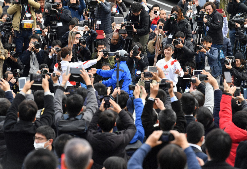大勢の人たちが沿道に集まる中、東京五輪聖火リレーのリハーサルをする関係者ら=東京都羽村市で2月15日、宮間俊樹撮影