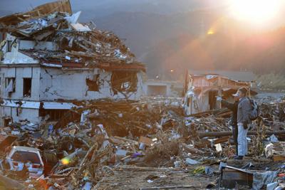 津波に飲み込まれた市街地を眺める人たち＝岩手県陸前高田市で２０１１年３月１２日午後５時８分、兵藤公治撮影