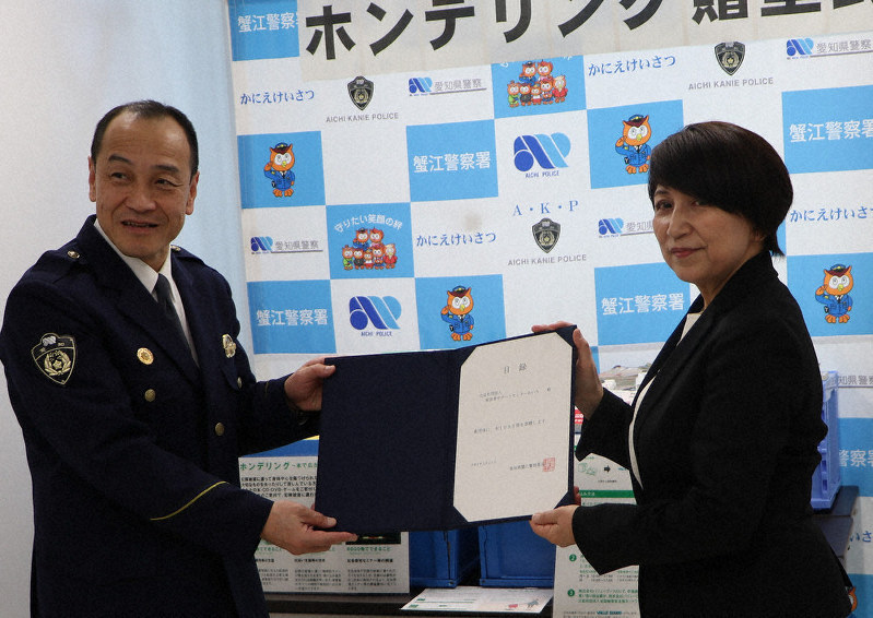 サポートセンターあいちの担当者に目録を渡す蟹江署の大橋孝雄署長(左)=愛知県警提供