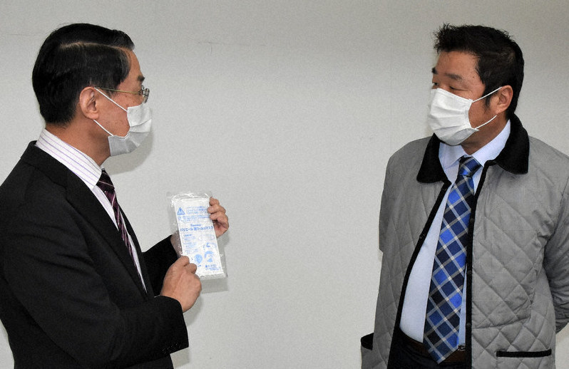 生産を開始したマスクについて、谷口健二社長(右)から工場内で説明を受ける平井伸治・鳥取県知事=鳥取市用瀬町用瀬で、野原寛史撮影