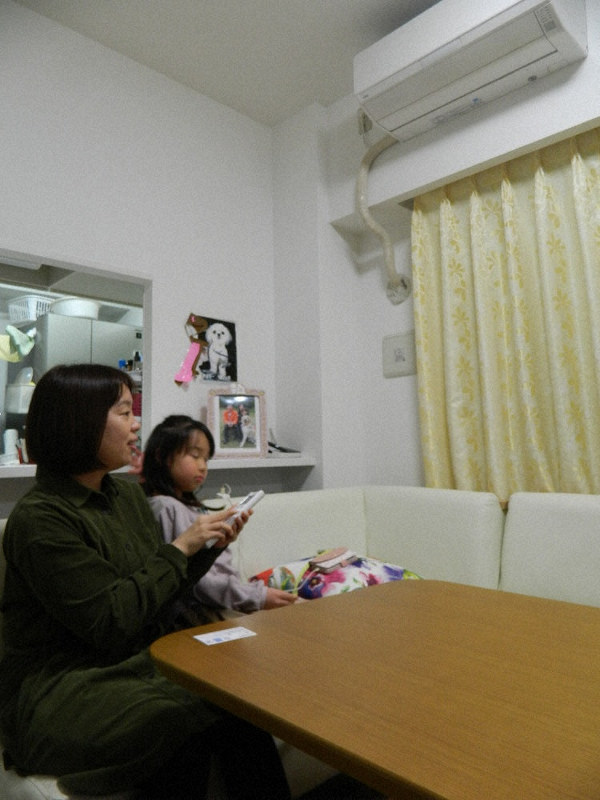 音声ガイド付きのエアコンをリモコンで操作する岡崎実穂さん(左)=大阪府内で4日、澤田健撮影