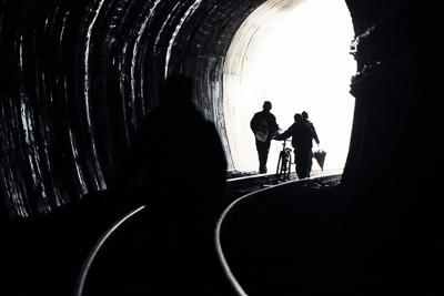 道路が寸断されＪＲ大船渡線のトンネルを歩いて市の中心部に向かって歩く人たち＝宮城県気仙沼市で２０１１年３月１５日、小関勉撮影