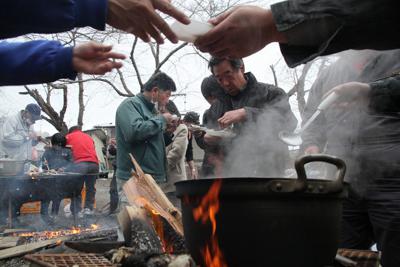 避難住民が自主的に始めた炊き出しで配られた魚料理を食べる住民。温かい食事は久しぶりだ＝岩手県宮古市で２０１１年３月１７日午後３時５８分、和田大典撮影