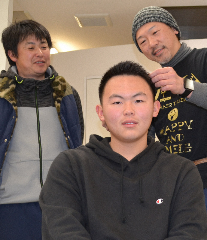 幼い頃から通うヘアスタジオで髪を切った古川真愛さん(中央)と、見守る父の倫愛さん(左)=岩手県釜石市大町で2月29日、中尾卓英撮影
