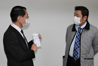 Taishi Co. President Kenji Taniguchi, right, presents a mask made at the firm's plant in Tottori, on March 10, 2020. (Mainichi/Hirofumi Nohara)
