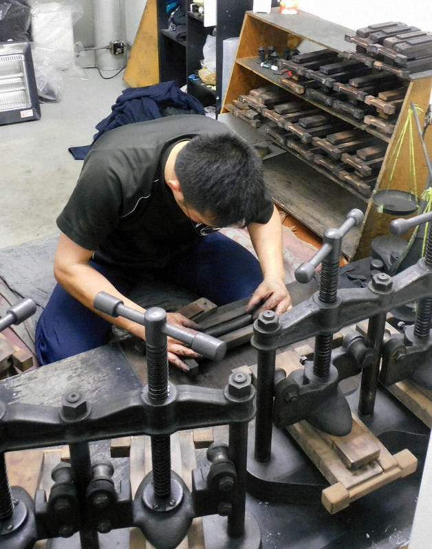墨を練って型に入れる職人。手前の道具でプレスして成形する=奈良市で、大森顕浩撮影