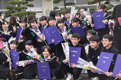 改修された校舎の前で記念撮影する卒業生たち＝倉敷市真備町箭田で、戸田紗友莉撮影