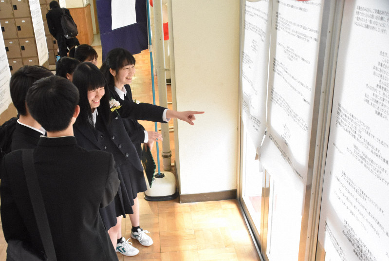 張り出されたメッセージを見て笑顔の卒業生=埼玉県所沢市北野新町で2020年3月13日、清藤天撮影