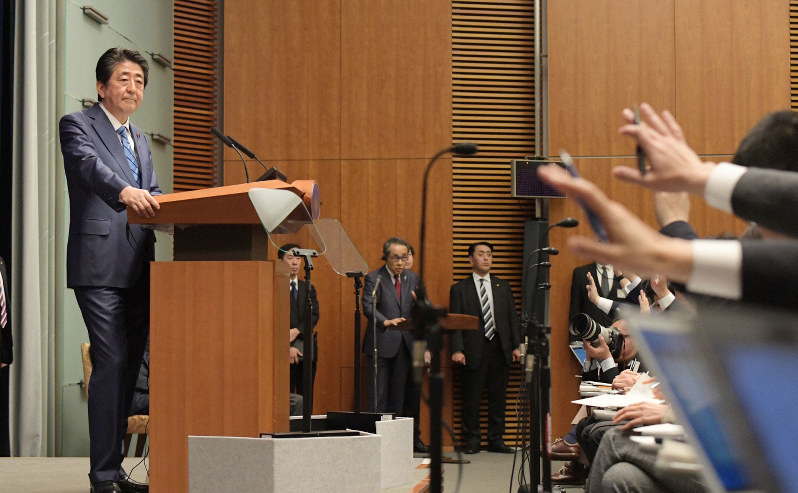 記者会見で挙手する記者たちを見る安倍晋三首相(左)=首相官邸で2020年3月14日午後6時31分、川田雅浩撮影