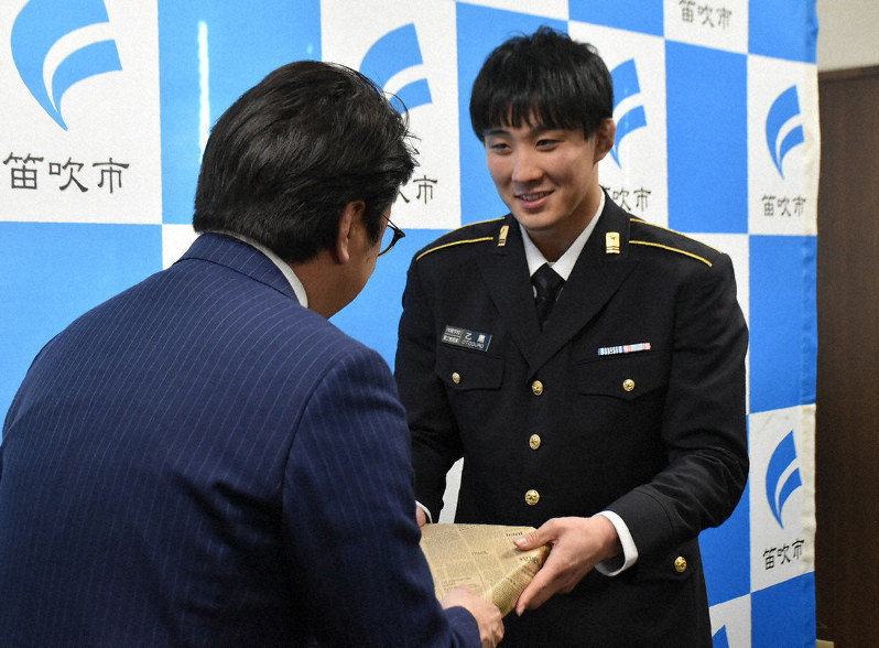 山下政樹市長(左)から記念品を受け取る乙黒圭祐選手=山梨県笛吹市役所で