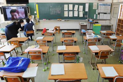 子どもたちのいない教室で自宅にいる児童の学習支援をする教師＝熊本県高森町の高森中央小で２０２０年３月１７日、津村豊和撮影