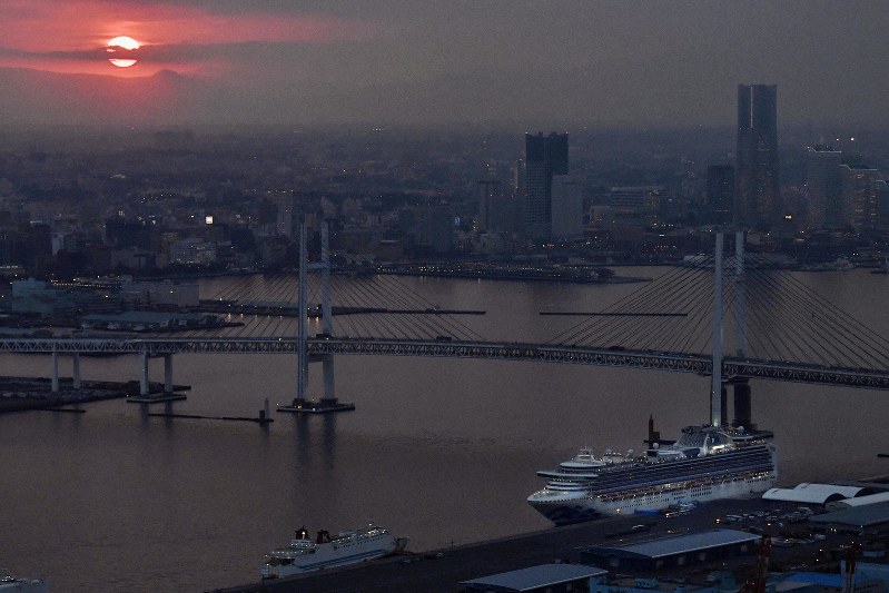 夕暮れ時、横浜港に停泊するクルーズ船「ダイヤモンド・プリンセス」(右下)=2020年2月20日、本社ヘリから