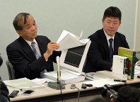 Lawyer Tadashi Matsumaru, left, who is representing the bereaved family of the former Finance Ministry official who took his own life, shows a page of documents released following a freedom of information request, which mostly has been blacked out, in Osaka's Kita Ward on March 18, 2020. (Mainichi/Tadashi Kako)