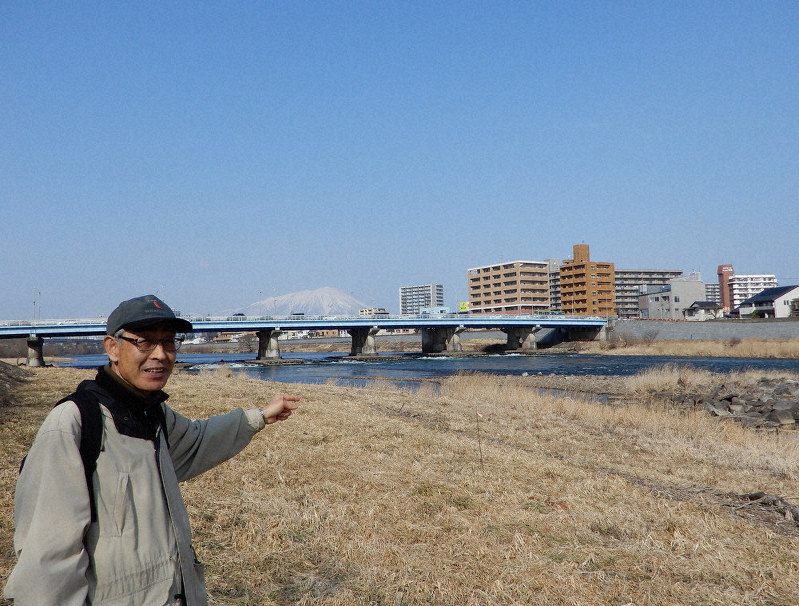 「このあたりに舟橋がありました」と案内してくれた大矢喜久男さん。奥は岩手山=盛岡市で2020年2月15日午前10時50分、広瀬登撮影