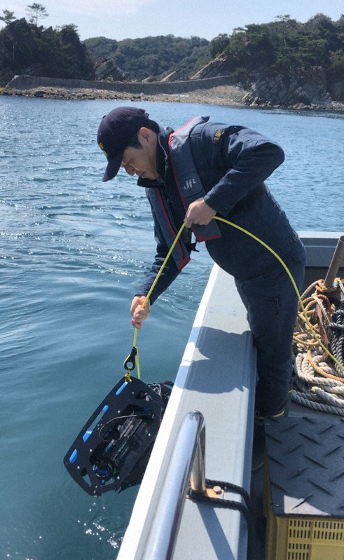 水中ロボットを海に下ろす巻俊宏准教授=東京大学生産技術研究所提供