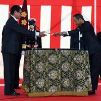 ジャパンマリンユナイテッドの千葉光太郎社長（手前右）からイージス艦「まや」の引き渡し署を受け取る河野太郎防衛相（同左）＝横浜市磯子区で２０２０年３月１９日午前１０時半、北山夏帆撮影