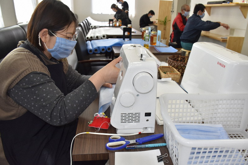 休業中の自社レストランホールを使い、分業してマスク作りに励む「あしなが田野」の通所者ら=宮崎市田野町甲のあしなが田野で2020年3月14日午後0時51分、塩月由香撮影