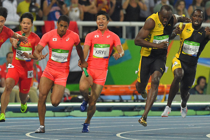 2016年リオデジャネイロ五輪男子400メートルリレー決勝で、桐生(中央)からバトンを受ける最終走者のケンブリッジ。日本は銀メダルに輝く。右から2人目はジャマイカの最終走者ボルト=和田大典撮影