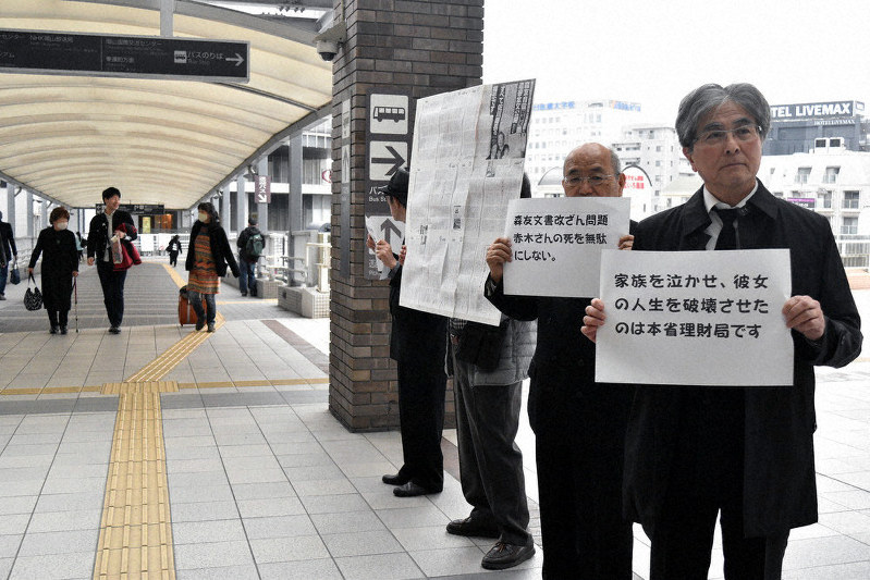 プラカードを手に立つ「森友文書改ざんを許さない市民の会」のメンバーら＝岡山市北区で、林田奈々撮影