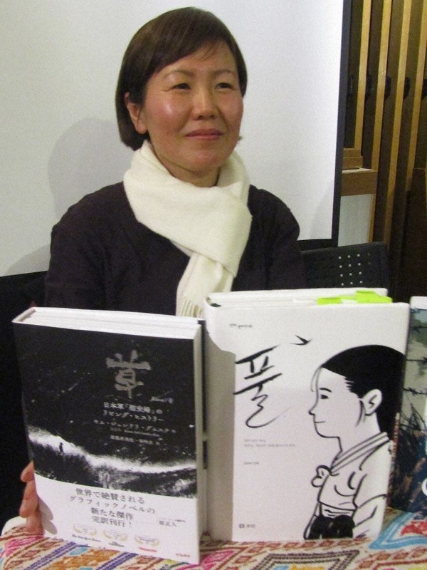 日本語版(左)と原書を手にする筆者のキムさん=東京都新宿区で
