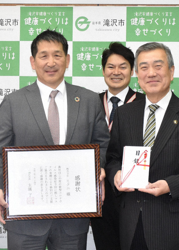 マスクの目録を持つ滝沢市の主浜了市長(右)と、感謝状を持つミクニの生田久貴社長(左)ら=滝沢市中鵜飼の滝沢市役所で
