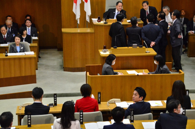 傍聴席から発言が相次いで騒然とし、議事が中断した横浜市議会。議長席周辺に各会派の市議が集まり、対応を協議した=横浜市中区の同市議会で2020年3月24日、樋口淳也撮影