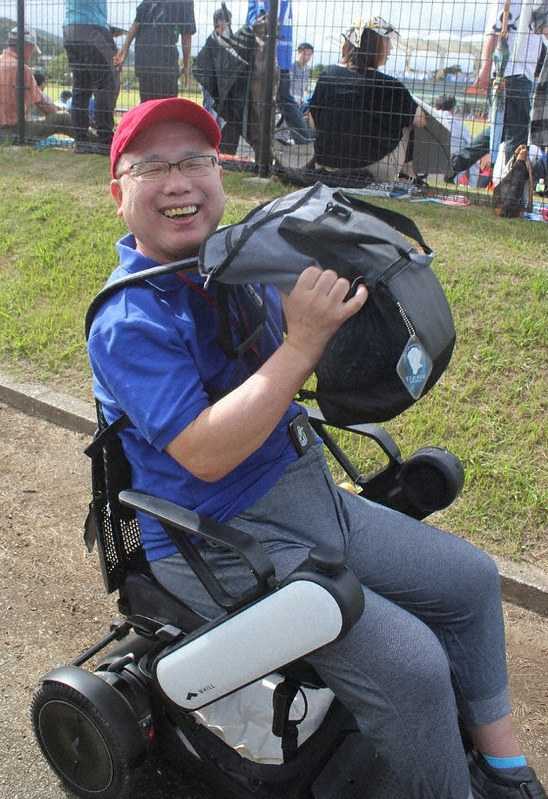 電動車椅子を駆使し、サッカー観戦などどこにも出かける久根崎さん=昨年9月、千葉県鴨川市陸上競技場で